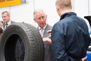 Prince Charles speaking to an apprentice next to car tyre