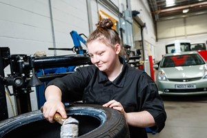 female apprentice checking a tyre