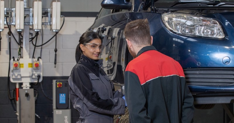 Technician and supervisor working on vehicle