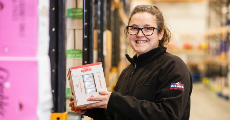 CJ Lang in a warehouse holding a box